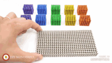 a person holding a piece of magnetic balls with the words " diy wonderful " on the bottom right