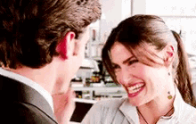 a man and a woman are laughing together and the woman is smiling .