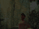 a man without a shirt is standing in a forest with his hands on his hips