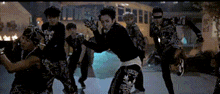 a group of people are dancing in front of a school bus