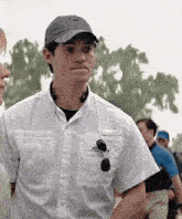 a man wearing a hat and a white shirt is standing next to a woman .
