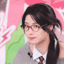 a woman wearing glasses and a tie looks to the side