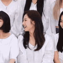 a group of women are sitting next to each other in a room and smiling .
