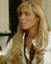 a woman with long blonde hair is wearing a white shirt and tie