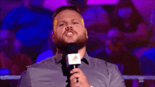 a man with a beard is holding a microphone that says x-c on it