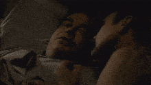 a man and woman are kissing in a dark room