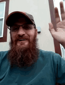 a man with a long beard wearing glasses and a hat