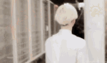a man wearing a white hat and a white shirt is walking in a room .