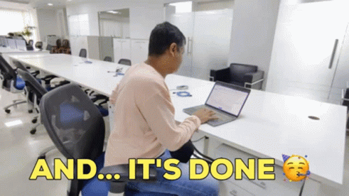 Person at a laptop in an office with text 'AND... IT'S DONE'