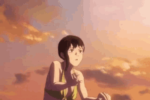 a girl in a bikini is standing on a beach at sunset looking up at the sky .