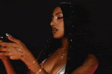 a woman with long black hair and a nose ring is wearing a very revealing dress .