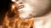 a close up of a person 's face with flames behind him .