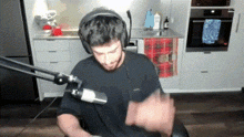 a man wearing headphones and a microphone in a kitchen