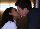 a man and a woman are kissing each other .