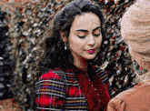 a woman in a plaid shirt is looking down at something