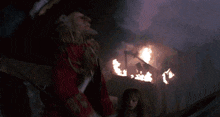 a person is standing in a dark room with a large explosion coming out of the ceiling .