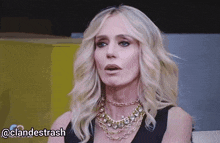 a woman wearing a necklace and a black dress has the hashtag @clandestinash on the bottom