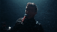 a man singing into a microphone with a black shirt that says calvin klein