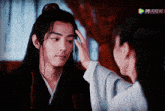 a woman touches a man 's forehead in a scene from a chinese movie