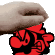 a close up of a hand holding a red object with a cartoon face on it .