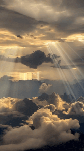 the sun shines through the clouds and mountains
