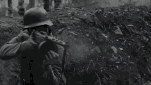 a man wearing a helmet is holding a gun in his hand