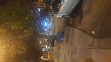 a silver car is parked on the side of a street at night