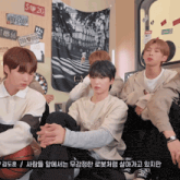 a group of young men are sitting in front of a wall with a tapestry that says wrv 269 on it