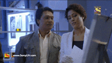 a man and a woman are standing in front of a screen that says sony tv