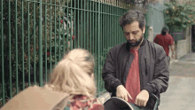a man and a woman are standing next to each other on a sidewalk .
