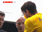 a man wearing a yellow jersey with the letter a on the back