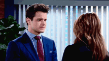 a man in a suit and tie is looking at a woman