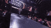 deonna purrazz is walking down a ramp in front of a crowd