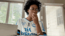 a woman wearing glasses and a white shirt that says tia