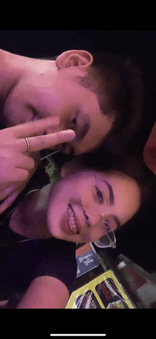 a man and a woman are posing for a picture and the woman is wearing braces on her teeth