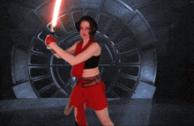 a woman in a red skirt is holding a lightsaber in front of a stormtrooper