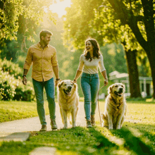 a man and a woman walking their dogs in a park