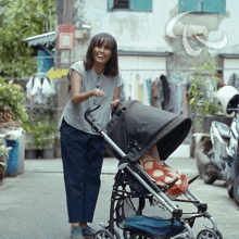a woman pushes a stroller down a street with a sign that says ' a ' on it