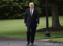 donald trump is wearing a suit and tie and walking down a road .