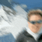 a blurry picture of a man wearing sunglasses and a jacket