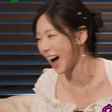 a close up of a woman laughing with her mouth open