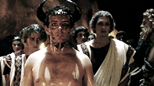 a shirtless man with horns on his head stands in a crowd