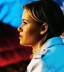 a close up of a woman 's face in a white jacket