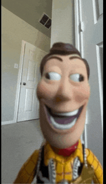 a woody doll is smiling in a room with a door in the background