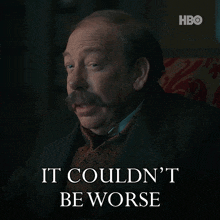 a man with a mustache is sitting in a chair with the words " it couldn 't be worse " below him