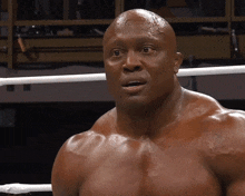 a man without a shirt is standing in a boxing ring looking at the camera