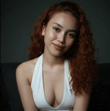 a woman with red hair is wearing a white tank top