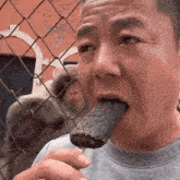 a man is eating an ice cream bar while a monkey looks on