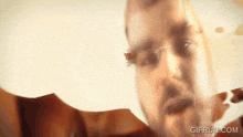 a close up of a man 's face with the words gifrun.com written below it