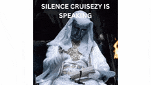 a man in a white robe is sitting in front of a fire with the words " silence cruisezy is speaking " above him